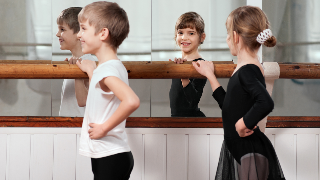 girl looking at reflection in the mirror while doing ballet