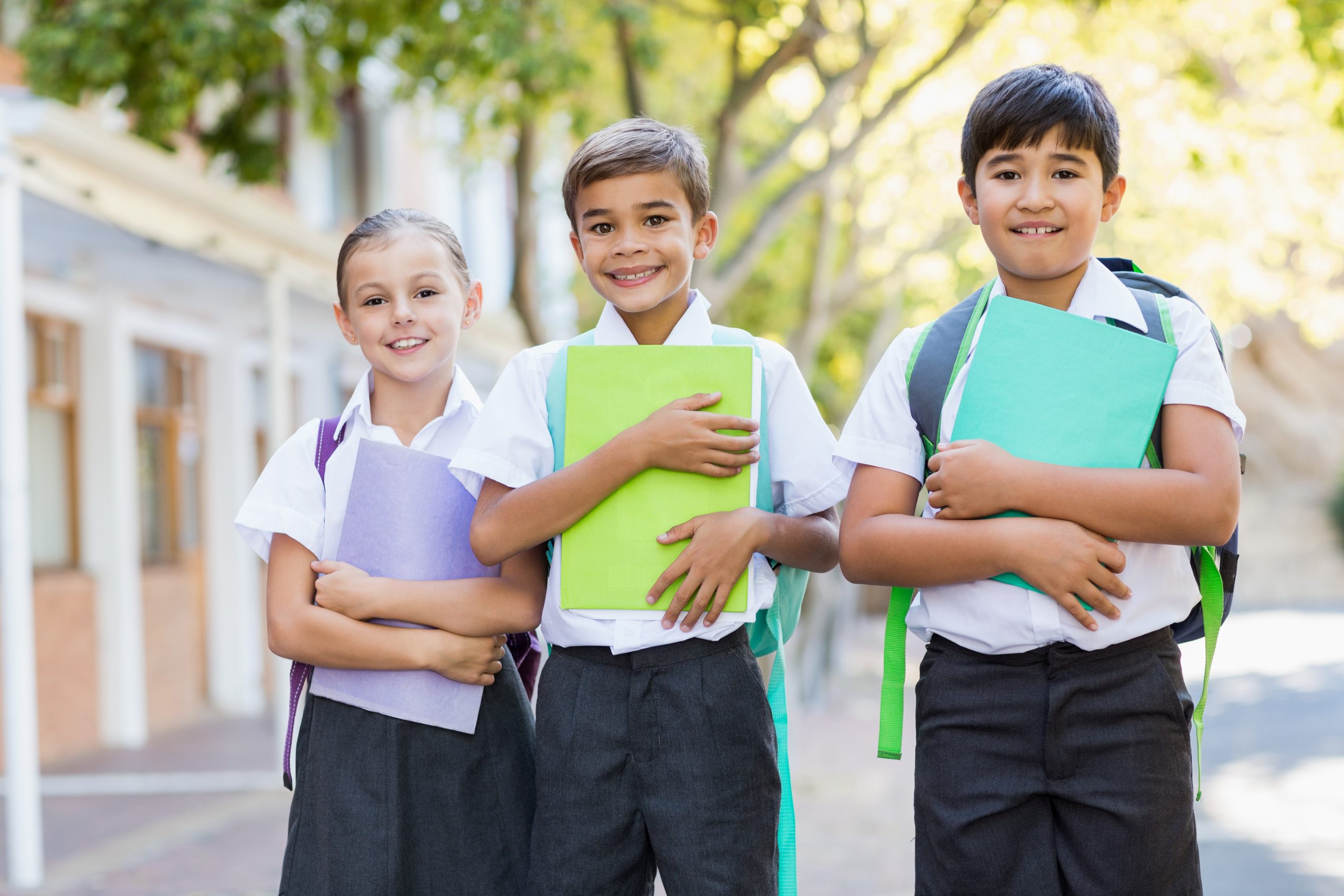 School experiences. Ученики стоят с буклетами. School Kids smiling. Действия в фотографиях ученик стоит.