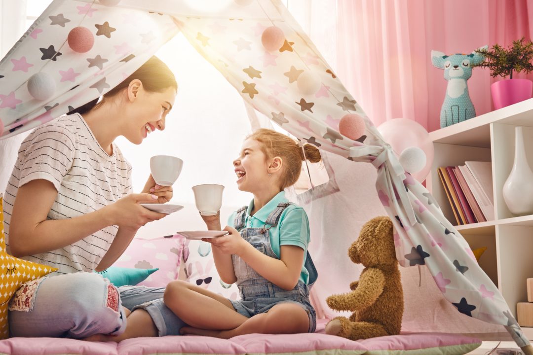 image of a happy mother and daughter having a tea party in a fort